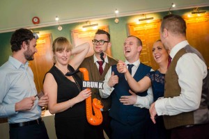 best man and guests having fun in photo booth
