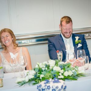 bride and groom laughing during wedding speeches