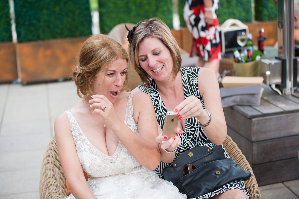 The bride is shown something shocking on a guests phone