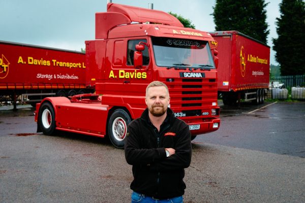 Andrew Davies standing in from of truck business owner