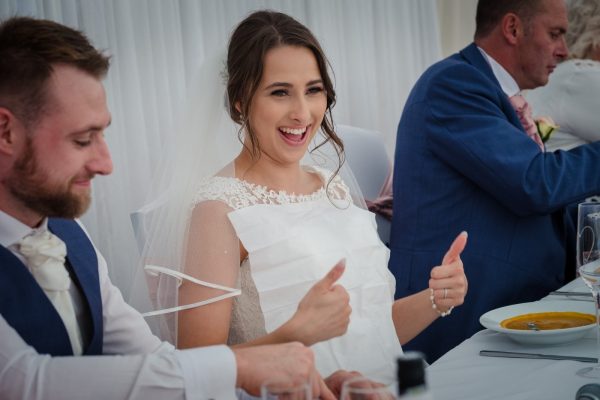 bride covers her dress with napkin rady for the wedding breakfast