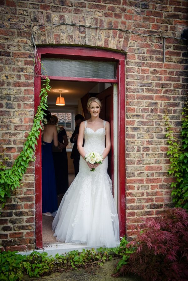 bride standing in doorway to cottages