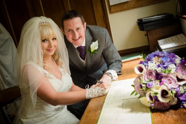 bride and groom sign register