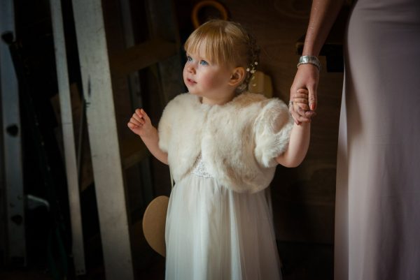 flower girl looks out of church doorway