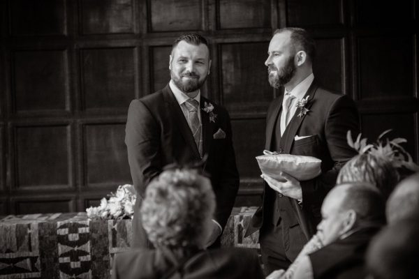 groom and best man wait at the front of the hall