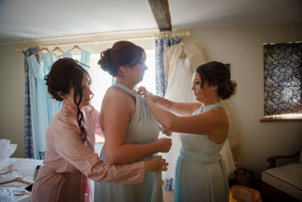 bridesmaids helping each other get ready