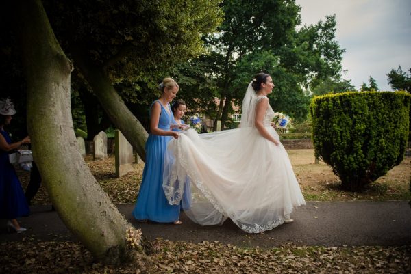 bride walks up path church alne north yorkshire