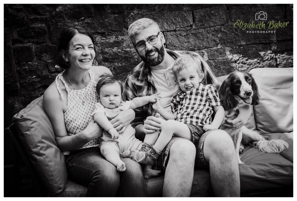 black and white family sitting with dog portrait