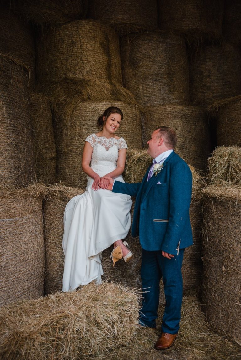hay bales in the barn with the couple