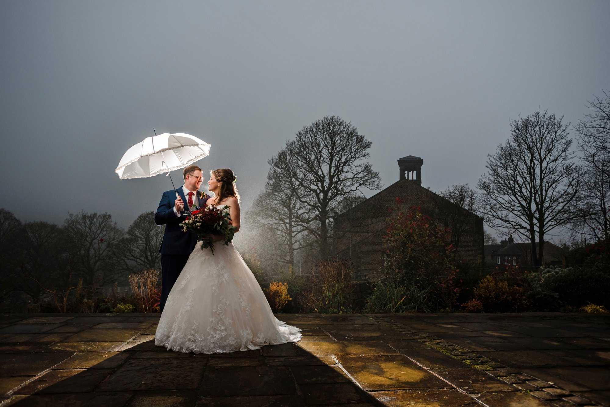 bride and groom in mist outside Dobcross church