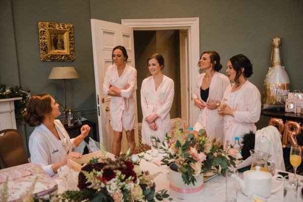 bridesmaids give the bride a gift box on the morning of the wedding