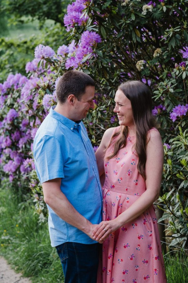 picturesque flowers behind engaged couple