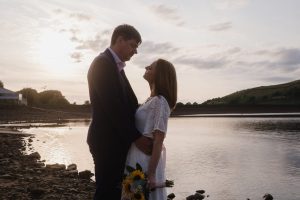 wedding couple romantic photo by a lake at sunset