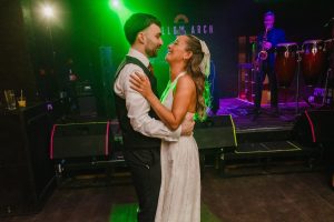 wedding couple have their first dance at Yellow Arch studios. Backlit by green light.